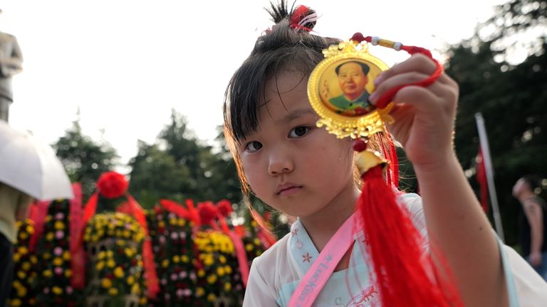 Mladá dívka slavící čínský národní den u sochy Mao Ce-tunga na místě jeho dětského domova ve vesnici Shaoshan v provincii Hunan