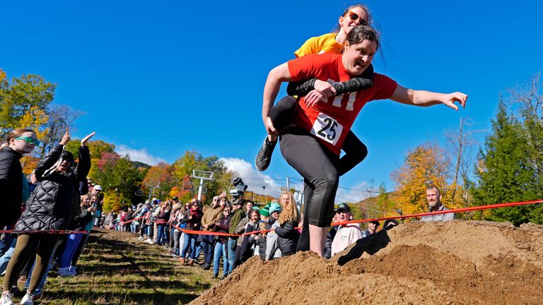 Molly Sunburn nese Megan Crowleyovou přes hromadu písku během North American Wife Carrying Championship. Obr: AP Photo/Robert F Bukaty