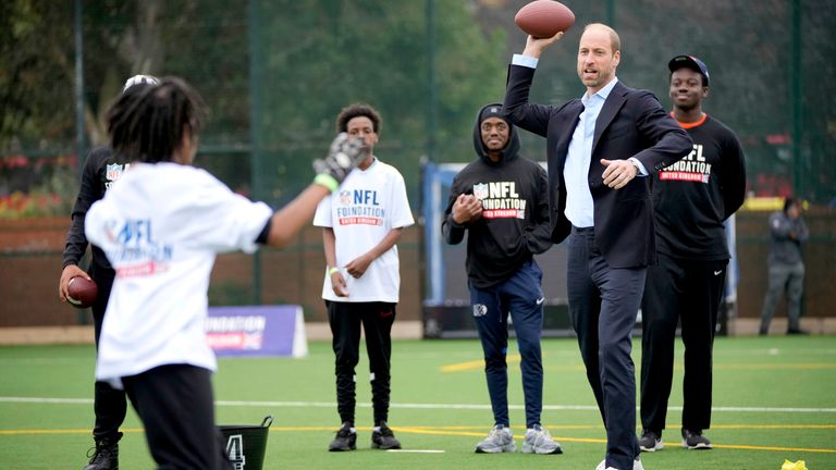 Princ z Walesu hází fotbalem, když se účastní akce NFL Foundation Flag.  Obrázek: AP