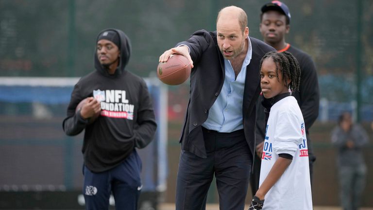 Princ z Walesu gestikuluje, když mluví s účastníkem akce NFL Foundation Flag.  Obrázek: AP