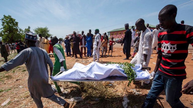 Lidé nesou tělo oběti výbuchu tankeru na pohřeb ve městě Majiya v Nigérii, ve středu 16. října 2024. (AP Photo/Sani Maikatanga)