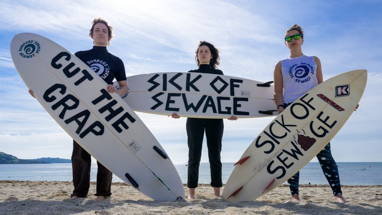 POUZE POUŽÍVEJTE REDAKCI JAZYK NA PLACARDS Lucy Luck, Evelyn Hull a Emily van de Geer se účastní protestu organizace Surfers Against Sewage (SAS) ve Falmouthu, která požaduje ukončení vypouštění odpadních vod sužujících britské řeky a moře. Datum snímku: Sobota 18. května 2024.