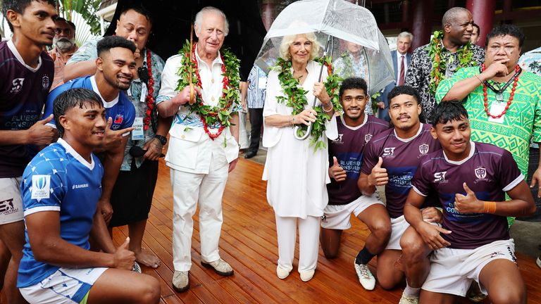 Král Charles a královna Camilla pózují s místními hráči rugby během návštěvy Samoa Cultural Village.  Snímek: Reuters