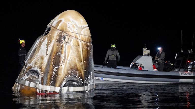 Podpůrné týmy s kosmickou lodí SpaceX Dragon Endeavour krátce poté, co přistála v Mexickém zálivu u pobřeží Floridy. Obrázek: NASA přes AP