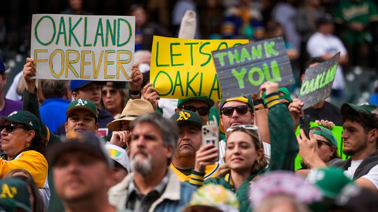 Fanoušci Oakland Athletics drží nápisy a skandují na tribunách poté, co Athletics prohráli 6:4 se Seattle Mariners v baseballovém zápase v neděli 29. září 2024 v Seattlu. (AP Photo/Lindsey Wasson)