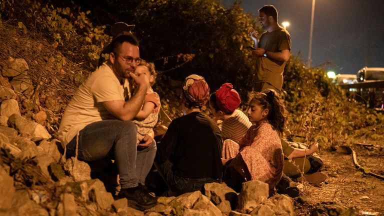 01.10.2024, Izrael, Tel Aviv: Lidé se kryjí na kraji silnice v Tel Avivu během varování před přilétajícími raketami odpálenými z Íránu. Autor fotografie: Ilia Yefimovich/picture-alliance/dpa/AP Images