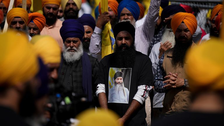 Truchlící má na sobě tričko s fotografií vůdce sikhské komunity a prezidenta chrámu Hardeepa Singha Nijjara před Antim Darshanem, první částí jeho celodenních pohřebních obřadů, v Surrey, Britská Kolumbie, neděle 25. června 2023. Nijjar byl zastřelen ve svém vozidle, když minulý týden opouštěl parkoviště Guru Nanak Sikh Gurdwara Sahib. (Darryl Dyck/The Canadian Press přes AP)