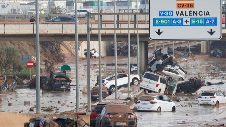 Poškozená auta jsou vidět podél silnice zasažené přívalovými dešti, které způsobily záplavy, na předměstí španělské Valencie.  Snímek: Reuters