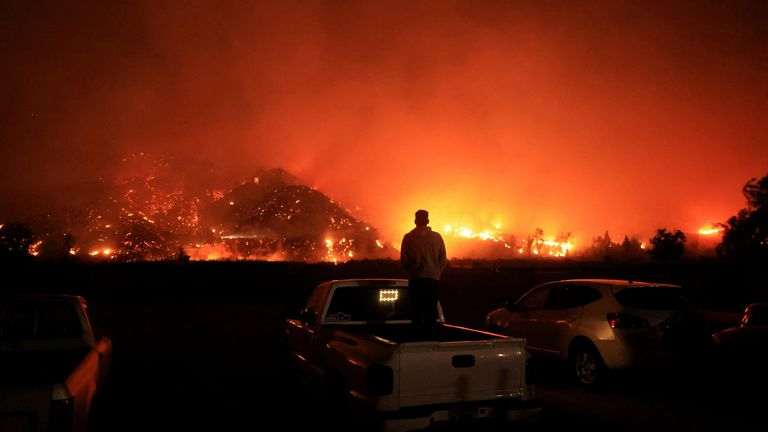 Člověk se dívá, jak se kouř a plameny valí z Mountain Fire v Santa Paula, Kalifornie, USA, 6. listopadu 2024. REUTERS/David Swanson TPX IMAGES OF THE DAY