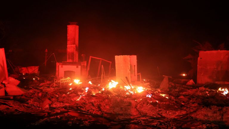 Plameny stoupají z poškozeného majetku, když se valí kouř z Mountain Fire v Camarillo, Kalifornie, USA, 6. listopadu 2024. REUTERS/David Swanson