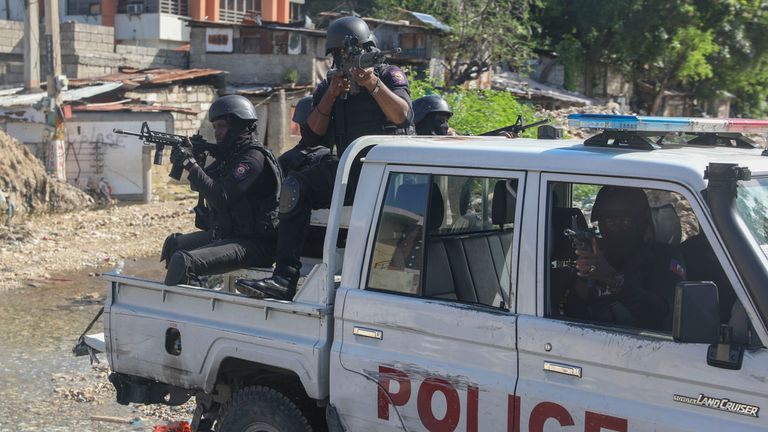 Policisté hlídkují v oblasti během přestřelky mezi gangy a policií v Port-au-Prince na Haiti, pondělí 11. listopadu 2024. (AP Photo/Odelyn Joseph)