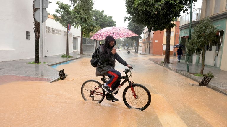 Cyklista přejíždí silnici poté, co se řeka Campanillas vylila v sousedství Campanillas poté, co španělská meteorologická agentura AEMET vydala červené výstrahy kvůli očekávaným silným dešťům, v Malaze, Obr: Reuters