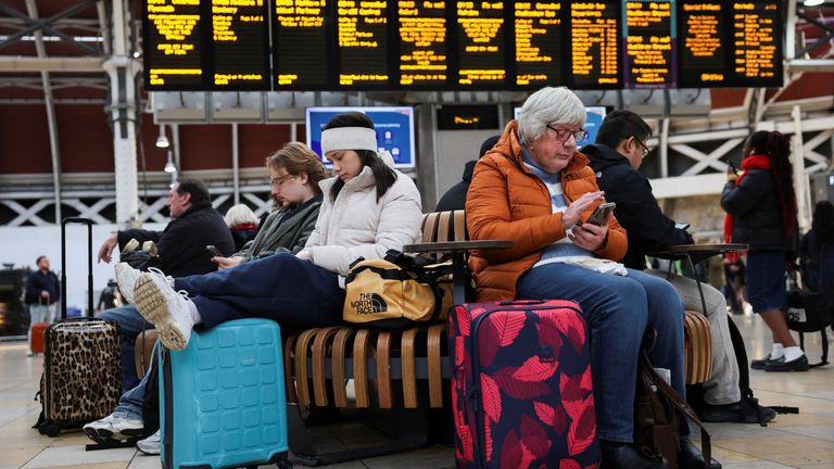 Železniční cestující čekají se svými zavazadly po zrušení vlaků způsobených Storm Bert na obrazovce na nádraží Paddington.  Snímek: Reuters