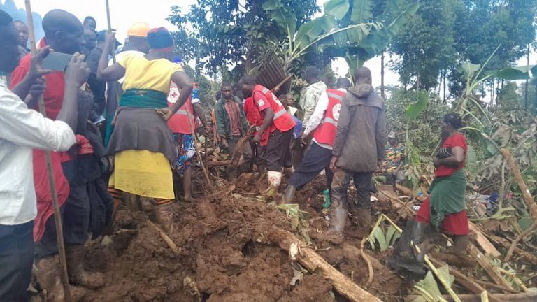 S pátráním po tělech pomáhají členové Ugandské společnosti Červeného kříže. Snímek: Reuters