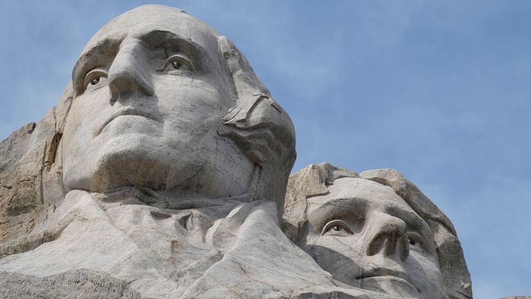 Návštěvníci si prohlédnou masivní sochu vytesanou do Mount Rushmore v Mount Rushmore National Memorial čtvrtek 21. září 2023 v Keystone, SD (AP Photo/David Zalubowski)