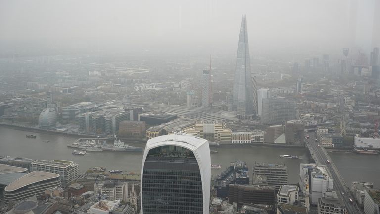 Pohled na Londýn z vyhlídkové plošiny Horizon 22 v Bishopsgate, jak je obloha zbarvena do šeda, což je způsobeno vysokým tlakem nad Spojeným královstvím, který zachycuje vlhkost blízko povrchu Země a vytváří tvrdohlavý mrak nebo, řečeno povětrnostním jazykem, „anticyklonální šero“ . Vysoký tlak má za následek slabý nebo žádný vítr, který by jinak pohyboval mrakem a rozbíjel ho. Datum fotografie: pátek 8. listopadu 2024.