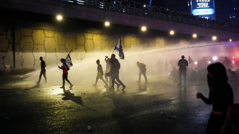 Policie pomocí vodního děla očistila skupinu lidí během protestu poté, co premiér Benjamin Netanjahu odvolal svého ministra obrany Yoava Gallanta v překvapivém oznámení v izraelském Tel Avivu ve středu 6. listopadu 2024. (AP Photo/Francisco Seco )