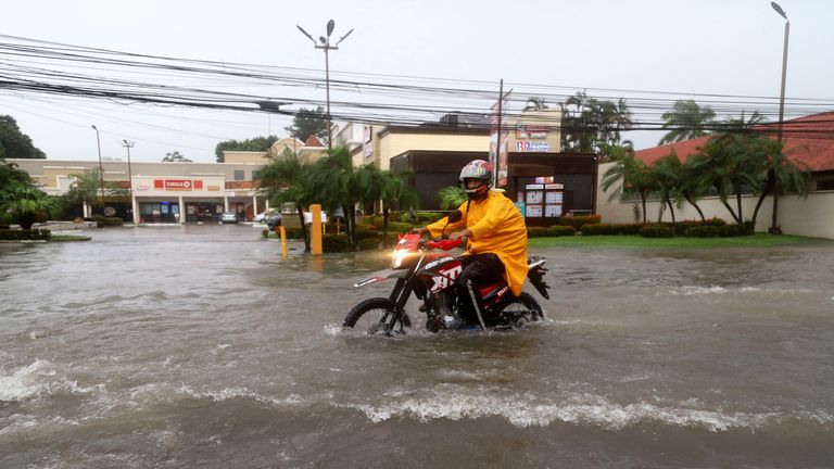 Motocyklista v zaplavené ulici v La Ceiba, Honduras. Snímek: Reuters