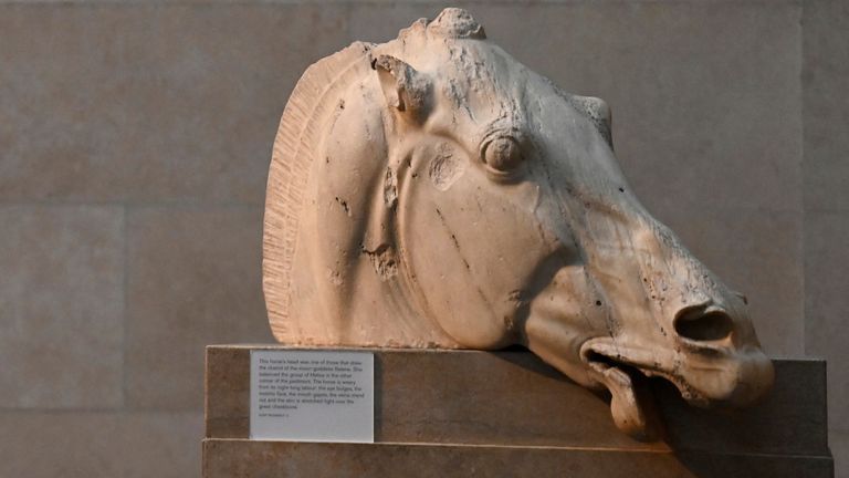 Zaměstnanec pózuje při pohledu na koňskou hlavu, která je součástí soch Parthenonu, někdy označovaných ve Spojeném království jako Elgin Marbles, vystavených v Britském muzeu v Londýně, Británie, 25. ledna 2023. REUTERS/Toby Melville