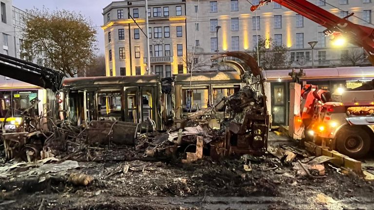 Vyhořel autobus a rozbitá okna na Luas na O'Connell Street, Dublin, Irsko. 