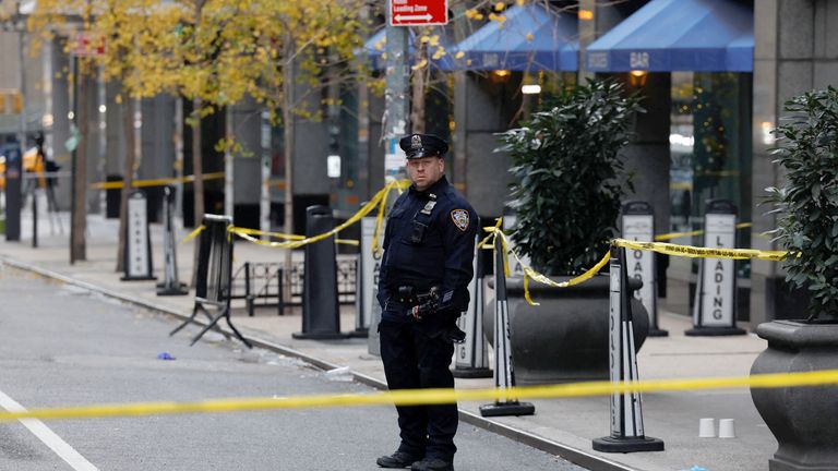 Policista stojí poblíž místa, kde byl údajně zastřelen generální ředitel United Healthcare Brian Thompson v Midtown Manhattan v New Yorku.  Obrázek Reuters