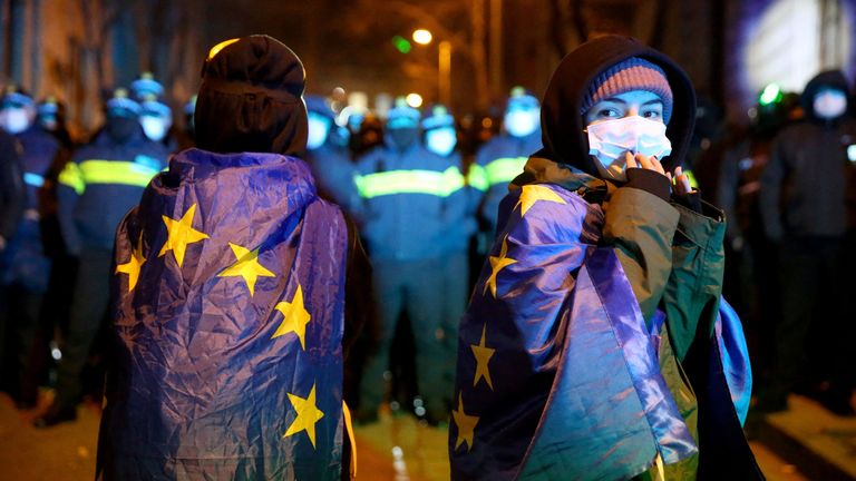 Lidé zahalení do vlajek Evropské unie se účastní shromáždění příznivců gruzínských opozičních stran na protest proti rozhodnutí vlády pozastavit rozhovory o vstupu do Evropské unie v Tbilisi, Gruzie 4. prosince 2024. REUTERS/Irakli Gedenidze