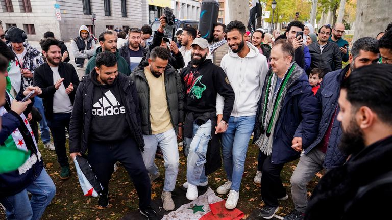 Lidé šlapou na vlajku syrské vlády během protestu na oslavu pádu režimu Bašára Asada před syrskou ambasádou v Madridu, Španělsko, 8. prosince 2024. REUTERS/Ana Beltran