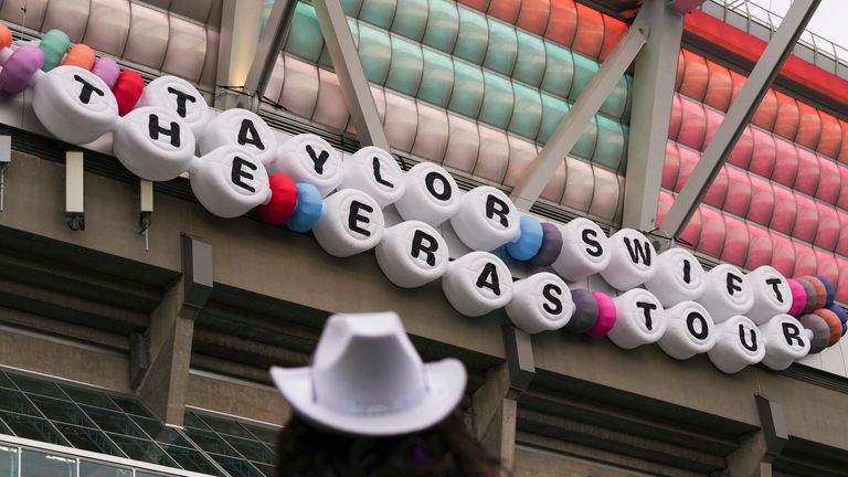 Návštěvník koncertu se dívá na nápisy Taylor Swift's "Eras Tour" v pátek 6. prosince 2024 ve Vancouveru v Britské Kolumbii. (AP Photo/Lindsey Wasson)