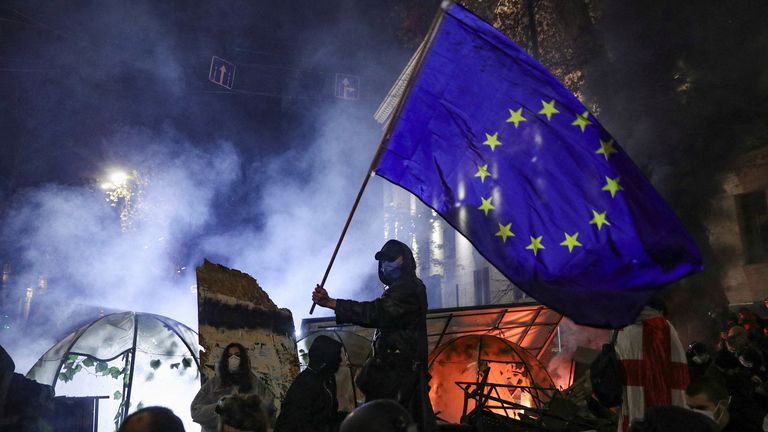 Během sobotních demonstrací v Tbilisi se demonstrant oháněl vlajkou EU. Snímek: Reuters