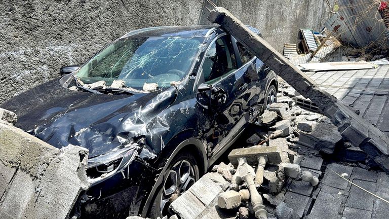 Vrak auta leží před domem, po cyklonu Chido, v Labattoir na Mayotte.  Snímek: Reuters