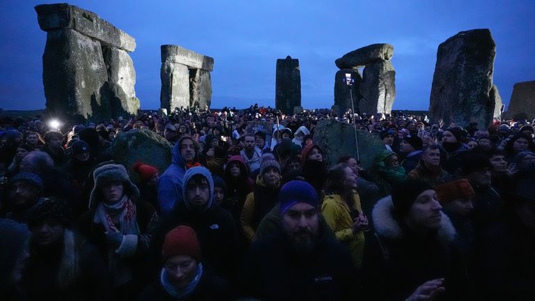 Lidé se účastní oslav zimního slunovratu během východu slunce u prehistorického monumentu Stonehenge na Salisbury Plain ve Wiltshire. Datum snímku: Sobota 21. prosince 2024.