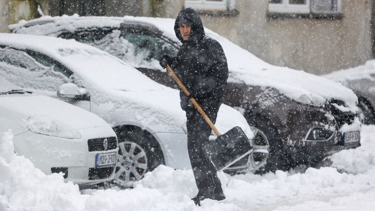 Muž odhazuje sníh z ulice během hustého sněžení v Bihac, Bosna, pondělí 23. prosince 2024. (AP Photo/Edvin Zulic)