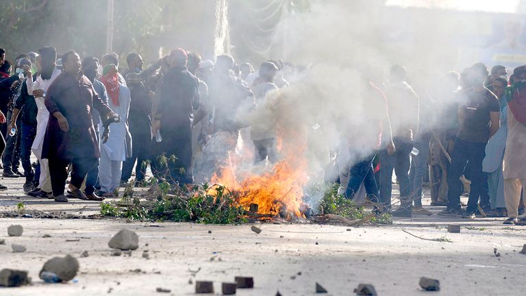 Stoupenci bývalého pákistánského premiéra Imrana Khana pálí pneumatiky a další materiál, když blokují silnici na protest proti zatčení svého vůdce, v Karáčí v Pákistánu v úterý 9. května 2023. Khan byl zatčen v úterý, když se objevil u soudu v hlavním městě země, Islámábádu, čelit obvinění z několika případů štěpu. Bezpečnostní agenti vytáhli Khana ven a strčili ho do obrněného auta, než ho odtáhli pryč. (AP Photo/Fareed Khan)