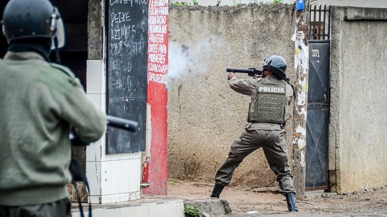 Policista míří svou zbraní na demonstranty v Maputo, Mosambik, čtvrtek 7. listopadu 2024. Demonstranti zpochybňují výsledek voleb 9. října, které viděly, že vládnoucí strana Frelimo prodloužila svou 49letou vládu. (AP Photo/Carlos Uqueio, soubor)