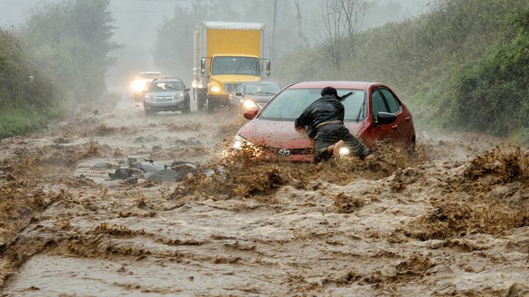 A local resident helps free a car that became stranded in a stretch of flooding road as Tropical Storm Helene strikes, on the outskirts of Boone, North Carolina, U.S. September 27, 2024. REUTERS/Jonathan Drake        SEARCH "REUTERS BEST 2024" FOR THIS STORY. SEARCH "REUTERS YEAR-END" FOR ALL 2024 YEAR END GALLERIES.          TPX IMAGES OF THE DAY