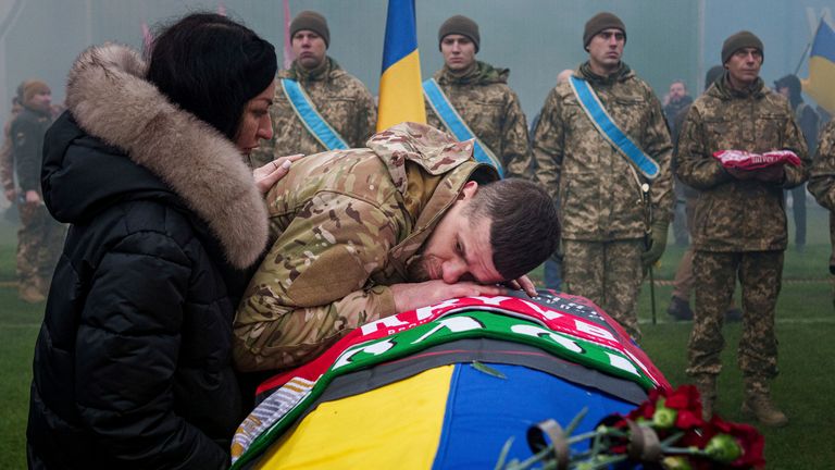 A Ukrainian serviceman bids farewell to his comrade Pavlo Vedybida aka "Obolonchik" at the Obolon Stadium in Kyiv, Ukraine, Saturday, Nov.  30, 2024. (AP Photo/Evgeniy Maloletka)