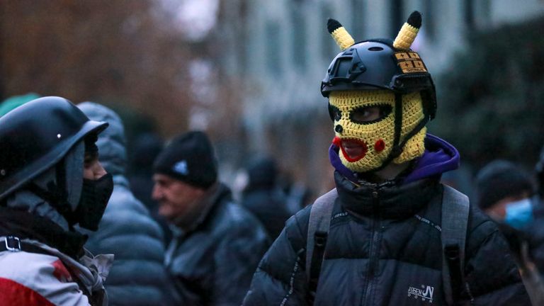 Demonstranti se v pondělí 25. listopadu 2024 shromáždili na ulici během shromáždění, aby požadovali nové parlamentní volby v zemi poblíž budovy parlamentu v gruzínském Tbilisi. (AP Photo/Zurab Tsertsvadze)