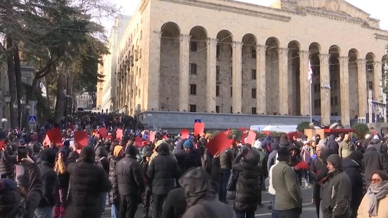 Demonstranti v Gruzii zesměšňovali jmenování bývalého fotbalisty Michaila Kavelašviliho novým prezidentem Gruzie tím, že drželi červené karty a kopali do kopaček.