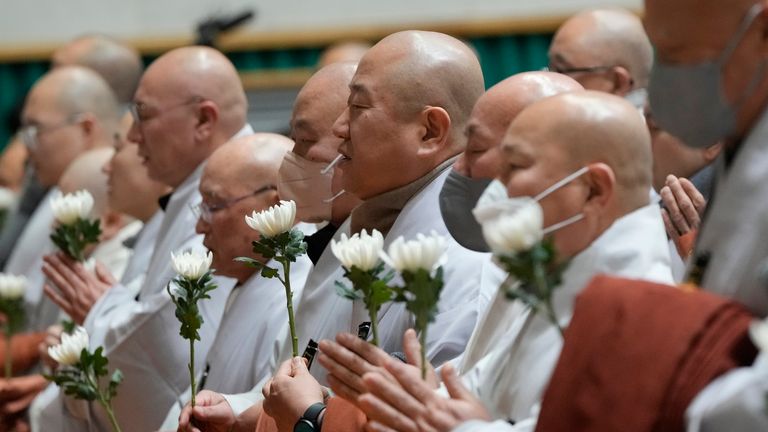 Buddhističtí mniši se modlí za oběti. (AP Photo/Ahn Young-joon)