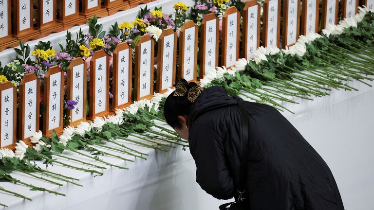 Žena se modlí u pamětního oltáře za oběti letecké havárie Jeju. REUTERS/Kim Hong-ji