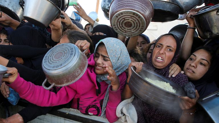 Palestinci se v Khan Younis v jižním pásmu Gazy, 19. listopadu 2024, shromažďují, aby dostali jídlo uvařené v charitativní kuchyni uprostřed hladové krize, kdy konflikt mezi Izraelem a Gazou pokračuje. REUTERS/Hatem Khaled TPX IMAGES OF THE DAY