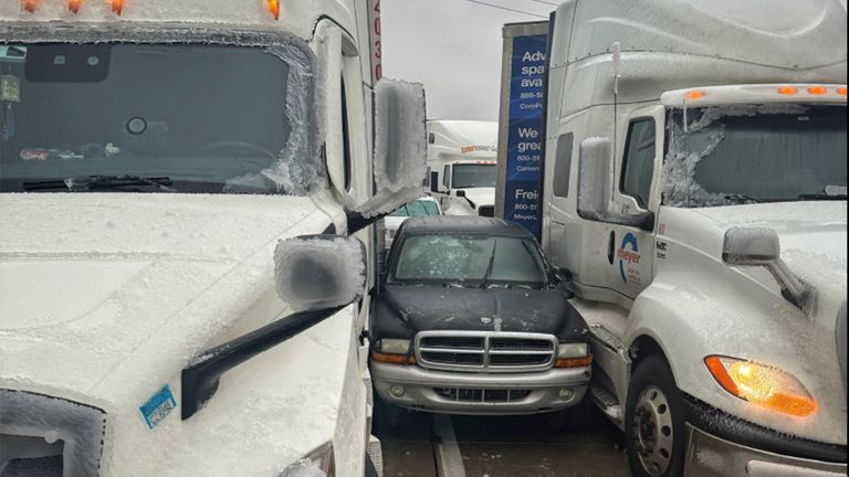 Osobní auto se po klouzání v náledí vklínilo mezi dva kamiony. Obr: Kansas Highway Patrol/AP