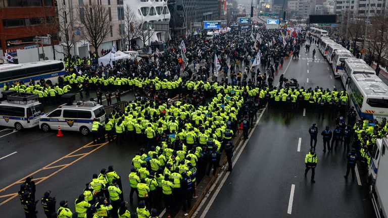 Policie stojí na stráži a blokuje silnici vedoucí k oficiální rezidenci obviněného jihokorejského prezidenta Yoon Suk Yeola, zatímco se demonstranti shromažďují v Soulu, Jižní Korea, 5. ledna 2025. REUTERS/Tyrone Siu