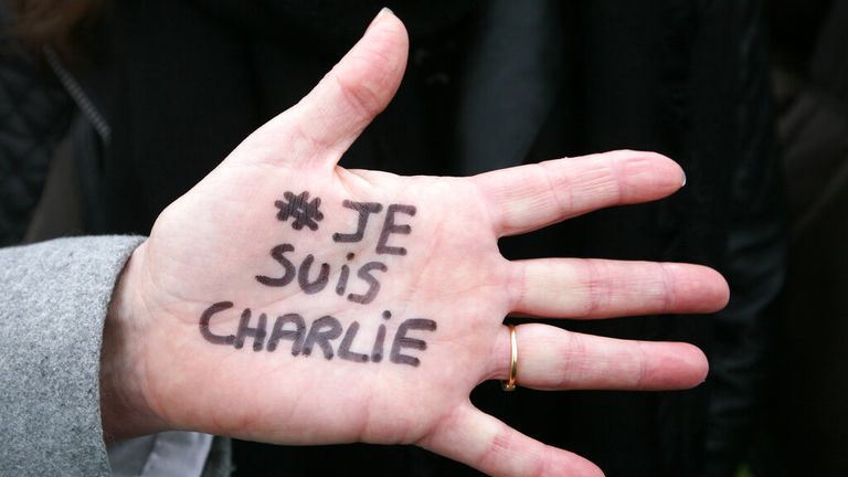 Brigitte Le Blein z Nice ukazuje, jak čte "Já jsem Charlie" během tichého pochodu za oběti střelby v satirických novinách Charlie Hebdo v sobotu 10. ledna 2015 v Nice na jihovýchodě Francie. Deset novinářů a dva policisté zahynuli 7. ledna při teroristickém útoku v sídle Charlie Hebdo v Paříži. (AP Photo/Lionel Cironneau)