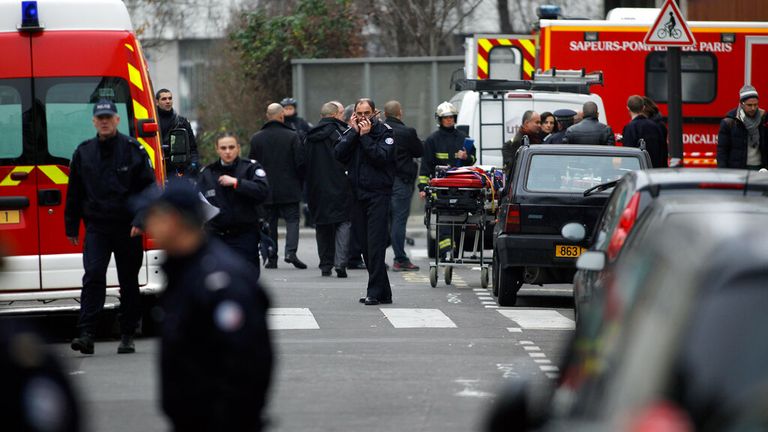 Policisté a hasiči se shromáždili před kanceláří francouzského satirického listu Charlie Hebdo v Paříži, ve středu 7. ledna 2015. Maskovaní ozbrojenci ve středu zaútočili na kanceláře francouzských satirických novin a před útěkem zabili nejméně 11 lidí, uvedla policie a svědek. . Týdeník již dříve vyvolal odsouzení ze strany muslimů. (AP Photo/Thibault Camus)