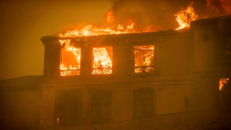 Rezidence hoří, zatímco Palisades Fire postupuje v sousedství Pacific Palisades v Los Angeles, úterý 7. ledna 2025. (AP Photo/Ethan Swope)