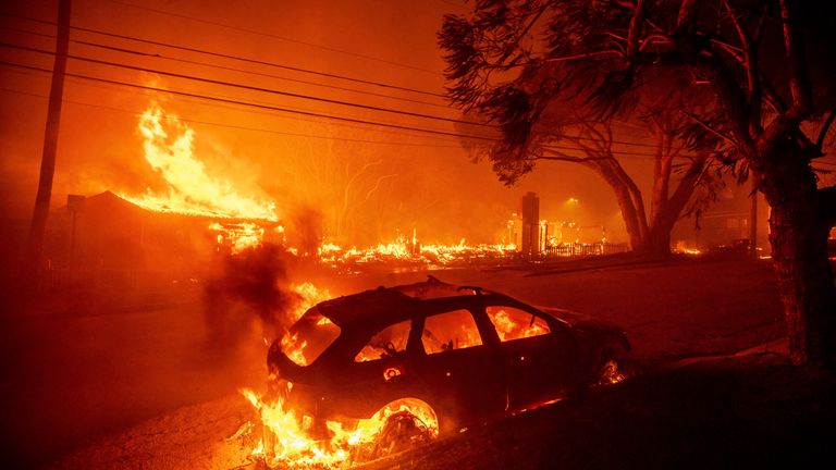 Požár Palisades spaluje vozidla a stavby v sousedství Pacific Palisades v Los Angeles, úterý 7. ledna 2025. (AP Photo/Ethan Swope)