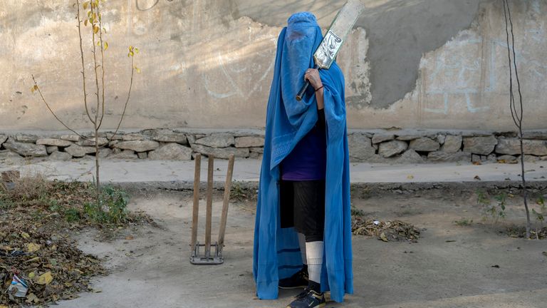 Afghánská žena pózuje na fotografii s kriketovou pálkou v Kábulu, Afghánistán, pátek 11. listopadu 2022. Vládnoucí Tálibán zakázal ženám sportovat a také jim zakázal většinu školní docházky a mnoha oblastí práce. Řada žen pózovala fotografovi agentury AP pro portréty s vybavením pro sporty, které milovaly. Ačkoli burky nutně nenosí v běžném životě, rozhodli se skrýt svou identitu svými burkami, protože se obávají represálií Talibanu a protože někteří z nich nadále tajně provozují své sporty. (AP Photo/Ebrahim Noroozi)