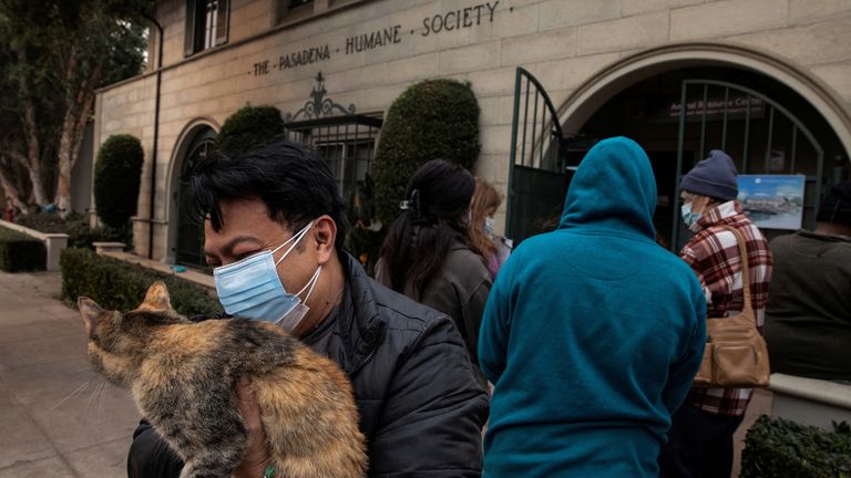 Edgar Hernandez před Pasadenou Humane Society, než se vzdá své kočky, poté, co evakuoval svůj domov v Altadeně.  Obrázek: Reuters/Zaydee Sanchez