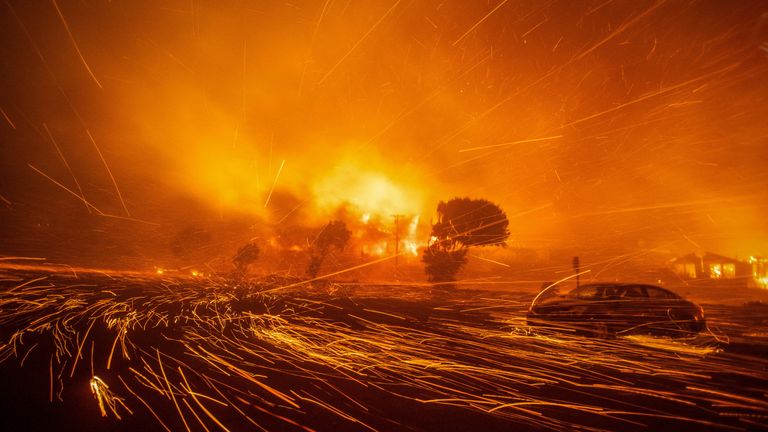 Vítr šlehá uhlíky z palisádového ohně.  Obrázek: Reuters/Ringo Chiu